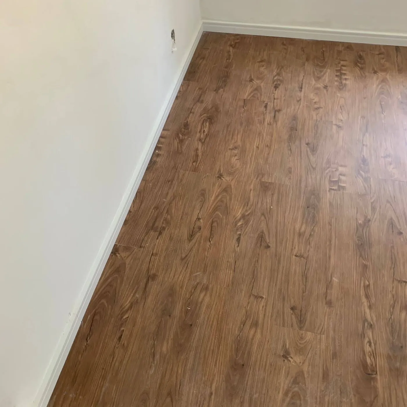 Sala com piso laminado em tom escuro instalado